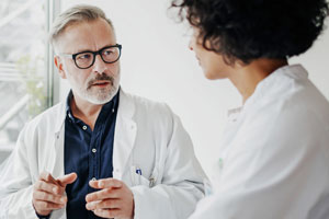 Arzt im Gespräch mit Patientin in Praxis, Beratung, Gesundheit.