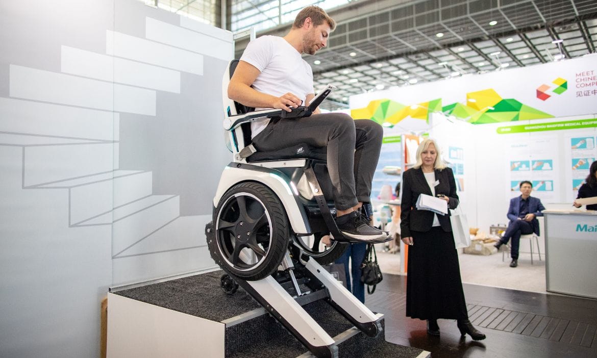 Mann nutzt motorisierten Rollstuhl auf einer Demo-Station bei einer Messe.