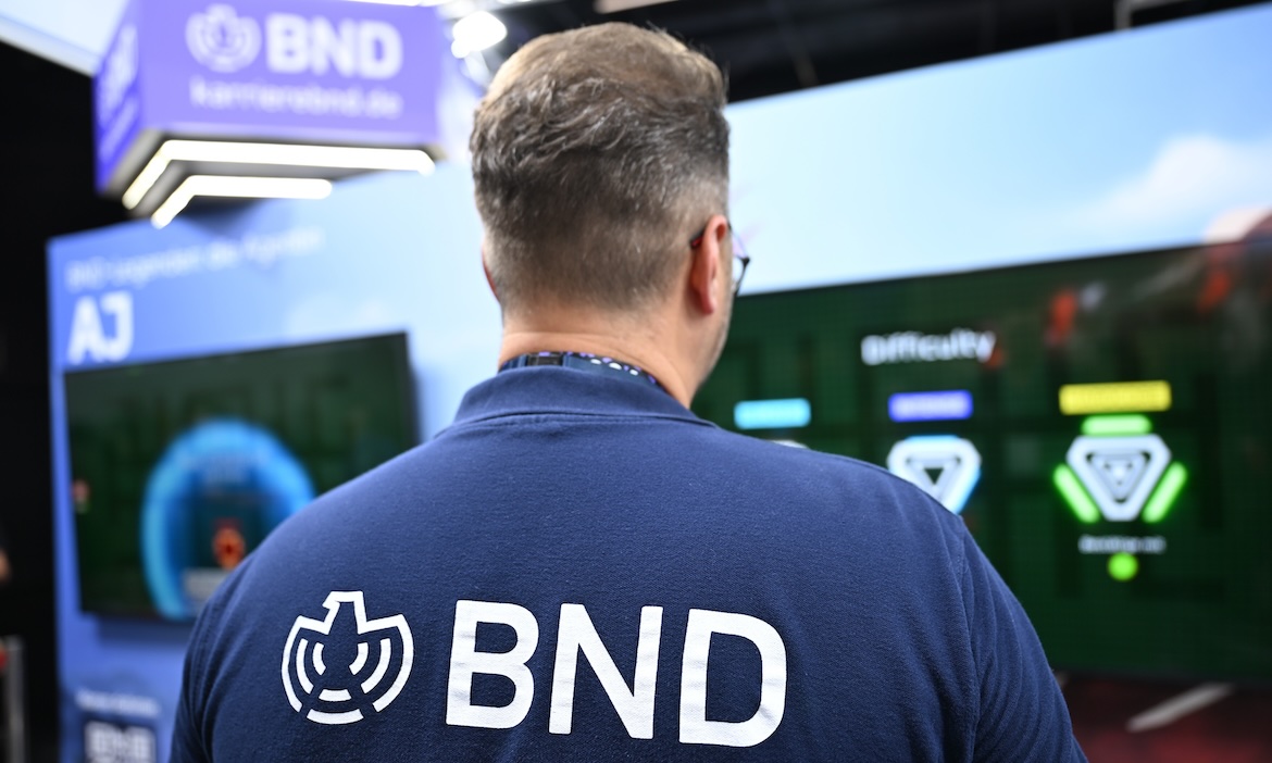 Ein Mitarbeiter des Bundesnachrichtendienstes (BND) steht an einem Messestand des BND auf der Gamescom in Köln.
