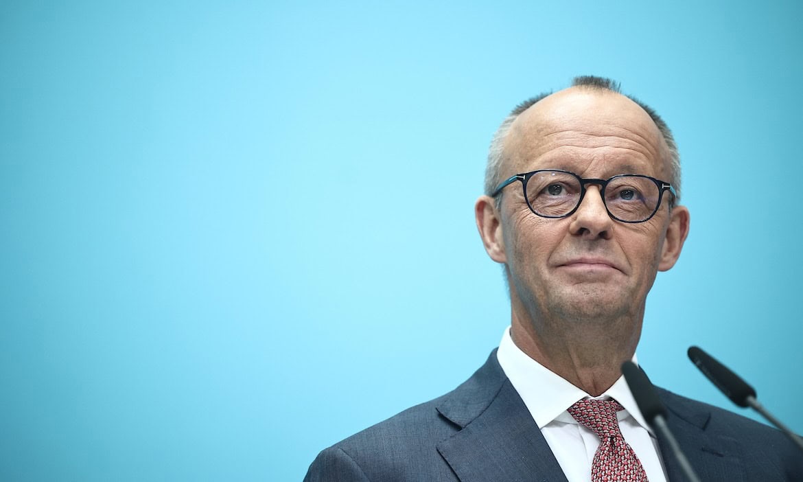 Mann in Anzug bei Podiumsdiskussion zu PKV und GKV.