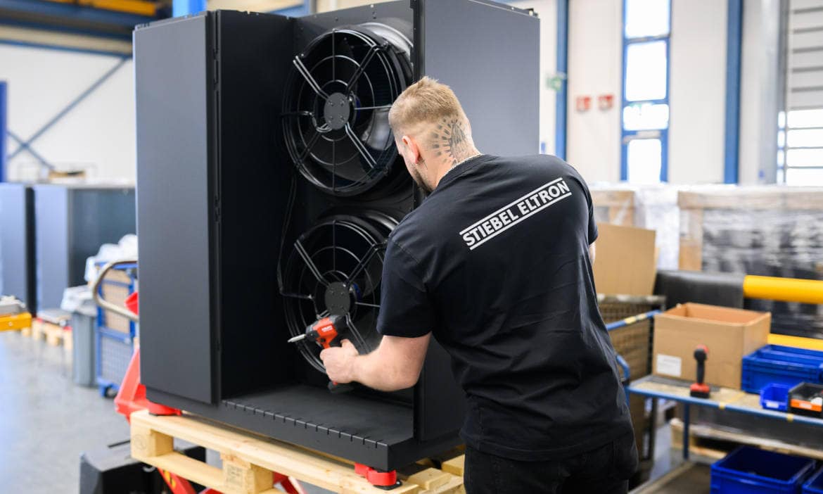 Techniker überprüft eine Heizungsanlage in einer Werkstatt.