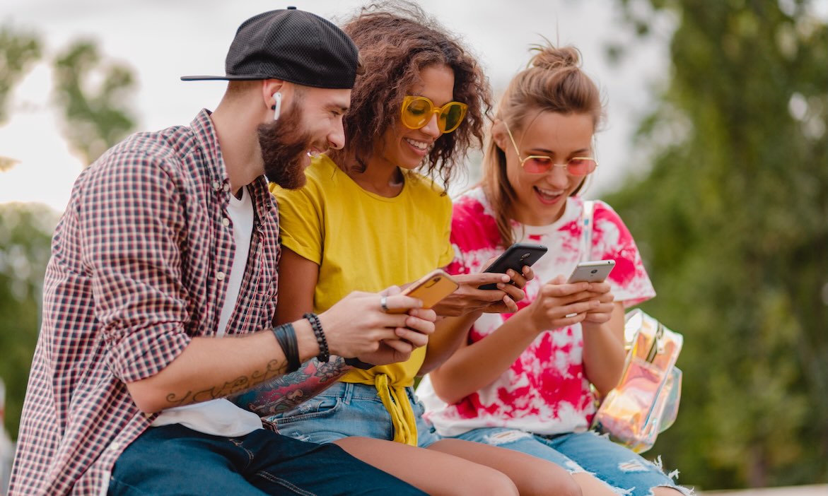 Junge Leute mit Smartphone: Gerade in den jüngeren Generationen ist das Interesse an dem Altersvorsorgedepot hoch.