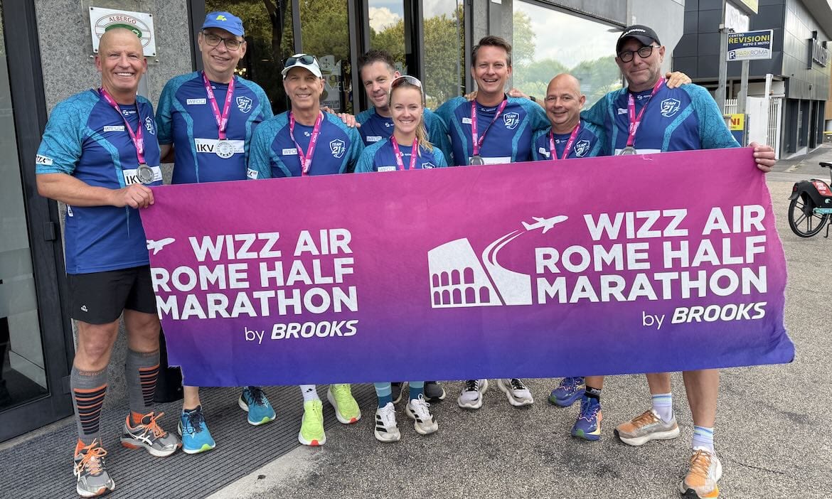 Lächelndes Marathon-Team mit WIZZ AIR Banner nach dem Lauf.